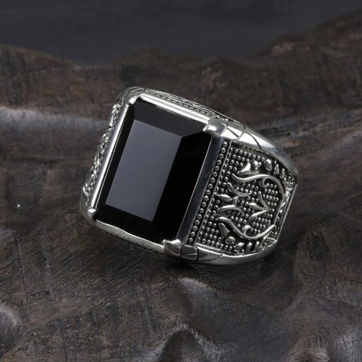 grosse-bague-en-obsidienne-noire-pour-homme-posee-sur-du-bois