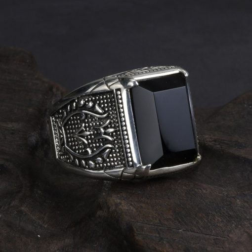 grosse-bague-en-obsidienne-noire-pour-homme-posee-sur-un-cailloux